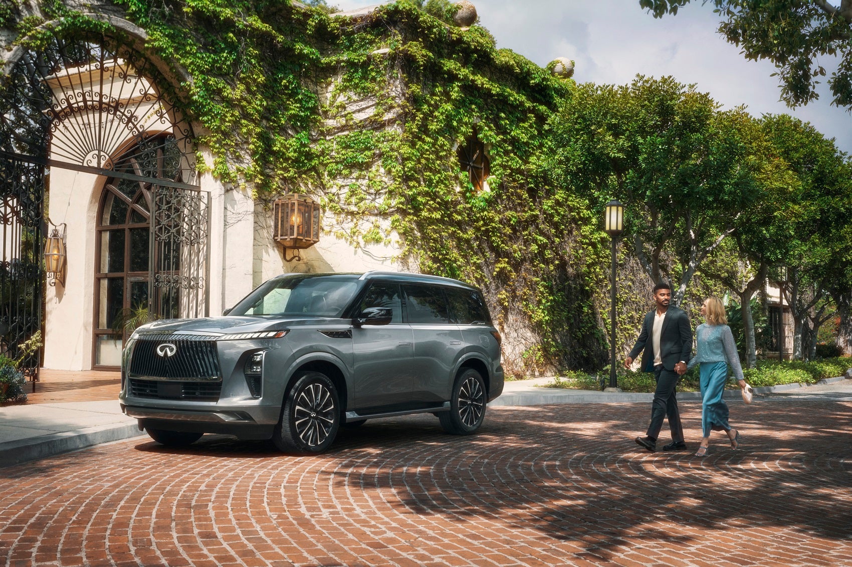 Couple walking up to a parked INFINITI QX80